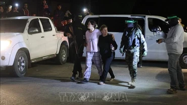 Các tay súng Hamas bàn giao nhóm con tin người Israel cho Ủy ban Chữ thập đỏ quốc tế tại Rafah, miền nam Dải Gaza, ngày 28/11/2023. (Ảnh tư liệu - minh họa: AFP/TTXVN)