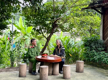Trung tá Ating Chơn trao đổi với già làng Bríu Pố về công tác giữ gìn an ninh trật tự tại địa phương