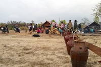 Phía trước mọi người chuẩn bị nấu nướng là hàng ghe rượu cần dựng sẵn chờ người thử.