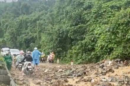 Nước mưa đã cuốn phăng đất, đá từ ta-luy trên cao tràn xuống mặt đường, gây mất an toàn giao thông, cản trở việc đi lại của người dân. (Ảnh: VŨ TÂN)