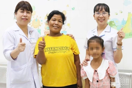 Bệnh nhi Sung Thị Khánh Hằng (8 tuổi, ở xã Lâm Sơn, tỉnh Khánh Hòa) cùng người thân chụp ảnh lưu niệm với các bác sĩ khoa Nhi (Bệnh viện Đa khoa Ninh Thuận, tỉnh Khánh Hòa trước khi xuất viện. (Ảnh: NGUYỄN TRUNG)