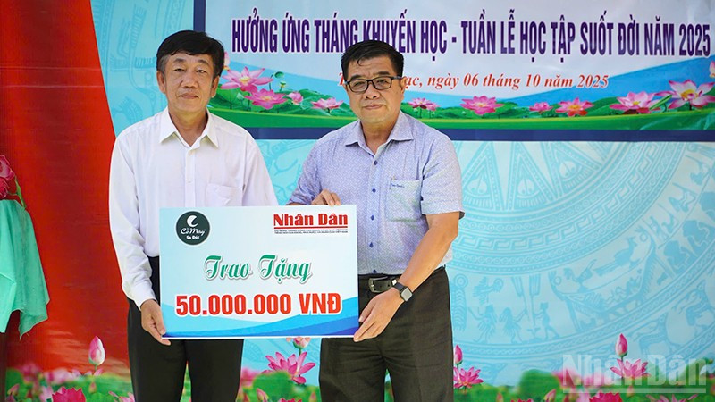 Ông Phạm Hữu Hoàn, đại diện Quỹ Xã hội Cỏ May trao 50 triệu đồng do Báo Nhân Dân vận động Quỹ để hỗ trợ học bổng tặng học sinh tại chương trình Phát học bổng hưởng ứng Tháng Khuyến học-Tuần lễ học tập suốt đời năm 2025.