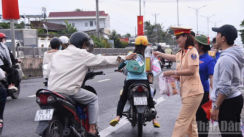 Các đơn vị, đoàn thể xã Châu Thành phát nước suối và khăn lạnh cho người dân về quê nghỉ lễ.