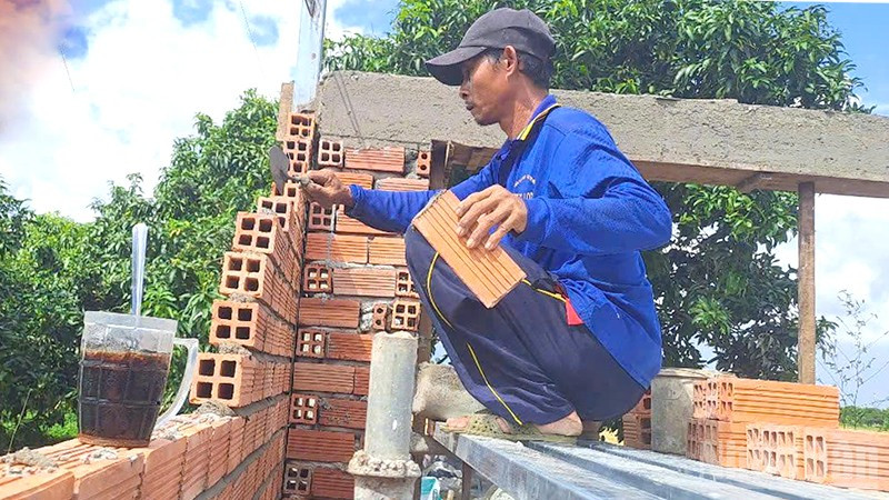 Thành viên Tổ cất nhà tình thương số 2, xã Định Yên, huyện Lấp Vò xây nhà cho người nghèo.