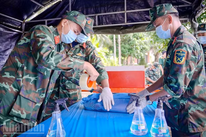 Đội lấy mẫu cẩn thận lấy mẫu hài cốt liệt sĩ chưa xác định được thông tin để phục vụ giám định ADN tại nghĩa trang liệt sĩ tỉnh An Giang, ở phường Rạch Giá.