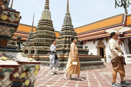 Khách du lịch trong trang phục truyền thống của Thái Lan tham quan chùa Wat Pho ở Bangkok. (Ảnh minh họa: Tân Hoa xã)