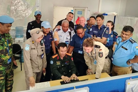 Thượng tá Phạm Văn Đoàn hướng dẫn lãnh đạo, cán bộ Phòng Tuần tra kiểm soát, Sở Cảnh sát thủ đô Juba sử dụng phần mềm xếp lịch tuần tra tự động do anh tự nghiên cứu, xây dựng. (Ảnh: Cảnh sát gìn giữ hoà bình Bộ Công an)