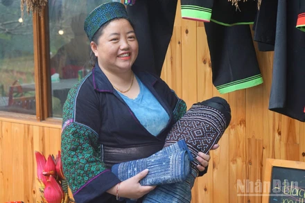 Chị Sùng Thị Lan, Giám đốc Hợp tác xã Mường Hoa giới thiệu về các sản phẩm truyền thống do chị em trong hợp tác xã làm ra. (Ảnh: TRUNG HƯNG)