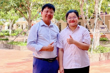 Thí sinh Nguyễn Thái An, học sinh trường THPT Kim Sơn A đạt điểm tuyệt đối 30/30 khối A00 và thầy giáo chủ nhiệm chụp ảnh lưu niệm. (Ảnh: Báo Ninh Bình)