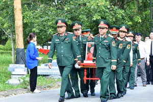 Lãnh đạo, chỉ huy Đoàn kinh tế-quốc phòng 337 và cấp ủy, chính quyền địa phương di chuyển hài cốt liệt sĩ về khu vực an táng.