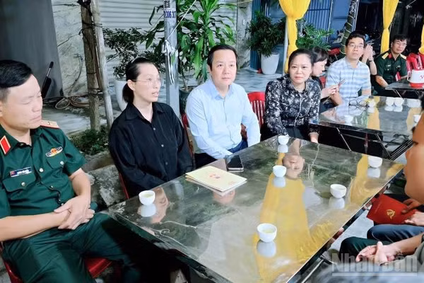 Đồng chí Bí thư Tỉnh ủy Hưng Yên Phạm Quang Ngọc (thứ 3 từ trái sang) thăm hỏi, động viên gia đình Thiếu tá Tùng hy sinh khi cứu người. (Ảnh: MAI TÚ)