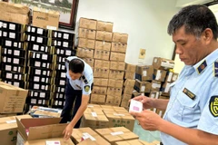 Lực lượng Quản lý thị trường thành phố Hà Nội kiểm tra một cơ sở kinh doanh hàng hóa có dấu hiệu vi phạm. (Ảnh: LƯU QUYÊN)