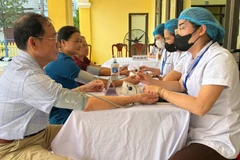 Cán bộ y tế kiểm tra sức khỏe định kỳ cho người dân trên địa bàn Hà Nội.