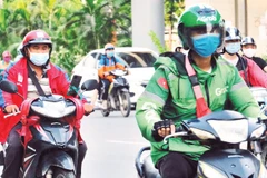 Tài xế xe công nghệ trên đường phố Hà Nội. (Ảnh: THẾ ĐẠI)