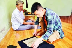 Sầm Công Danh (bên phải) tìm kiếm tư liệu trong cộng đồng.