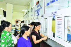 Người dân làm thủ tục khám, chữa bệnh bảo hiểm y tế tại Bệnh viện K cơ sở Tân Triều. (Ảnh: KHÁNH AN)