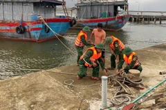 Lực lượng vũ trang thành phố Huế giúp người dân neo đậu tàu thuyền tránh bão. (Ảnh: VÕ TIẾN)