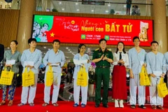 Lãnh đạo Bệnh viện Quân y 175 và nhà hảo tâm trao quà cho bệnh nhân có hoàn cảnh khó khăn đang điều trị tại bệnh viện. (Ảnh: Vương Lê)