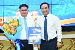 Chủ tịch Ủy ban nhân dân Thành phố Hồ Chí Minh Nguyễn Văn Được trao quyết định, tặng hoa chúc mừng đồng chí Nguyễn Mạnh Cường. (Ảnh: VIỆT DŨNG)