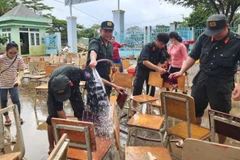 Lực lượng của Công an tỉnh Khánh Hòa hỗ trợ dọn vệ sinh tại Trường trung học cơ sở Nguyễn Đình Chiểu, phường Tây Nha Trang.