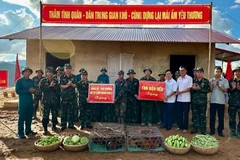 Thiếu tướng Nguyễn Đăng Khải và đồng chí Phạm Đức Toàn, Phó Chủ tịch Ủy ban nhân dân tỉnh Điện Biên trao quà, động viên các cán bộ, chiến sĩ đang giúp nhân dân làm nhà ở mới tại điểm tái định cư bản Háng Pù Xi, xã Xa Dung. (Ảnh: ĐỨC HẠNH)