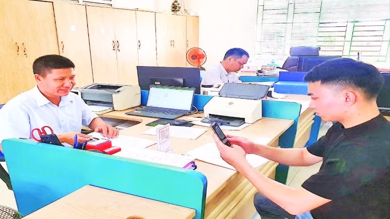 Cán bộ của Trung tâm Hành chính công huyện Hải Hà hướng dẫn người dân cài đặt ứng dụng thanh toán không dùng tiền mặt trên điện thoại thông minh.