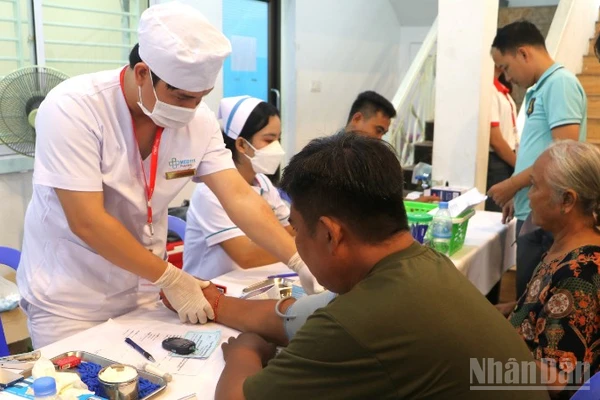 Các y, bác sĩ ân cần khám bệnh cho người dân. (Ảnh: HUY VŨ)