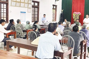 Cán bộ xã đối thoại với người dân có đất được thu hồi để triển khai dự án điện.