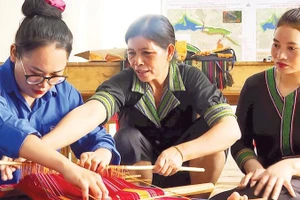 Nghệ nhân H'Yon (giữa) tỉ mỉ truyền dạy cho các học viên về cách tạo hoa văn trên nền thổ cẩm truyền thống của người M'nông bản địa.
