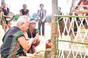 Chủ lễ thực hiện nghi thức tưới rượu cần lên cây Blang và các vật cúng tế trong Lễ Tăm Blang m’prang bon của người Mnông Pré, Nam Nung, Lâm Đồng.