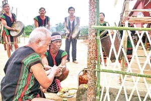 Chủ lễ thực hiện nghi thức tưới rượu cần lên cây Blang và các vật cúng tế trong Lễ Tăm Blang m’prang bon của người Mnông Pré, Nam Nung, Lâm Đồng.