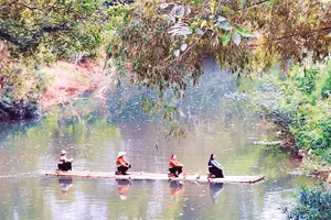 Khách du lịch trải nghiệm chèo bè mảng trên suối.