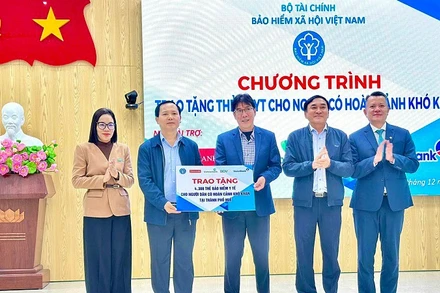 Phó Giám đốc Chu Mạnh Sinh, đại diện Bảo hiểm xã hội Việt Nam và các nhà tài trợ trao biểu trưng tặng hơn 4.000 thẻ bảo hiểm y tế cho bà con có hoàn cảnh khó khăn ở thành phố Huế. (Ảnh VSS)