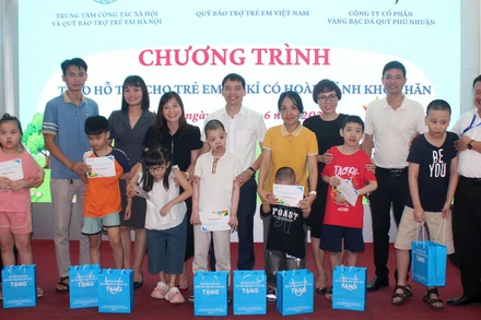 Các đại biểu trao hỗ trợ cho trẻ tự kỷ có hoàn cảnh khó khăn tại Hà Nội. (Ảnh NFVC)