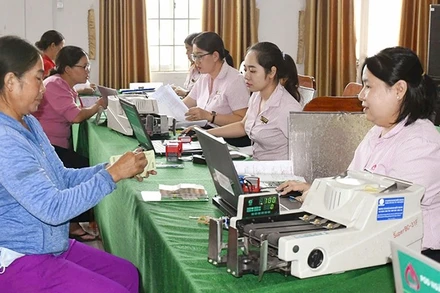 Giải ngân vốn vay cho hộ mới thoát nghèo tại Chi nhánh Ngân hàng Chính sách xã hội tỉnh Đắk Lắk. (Ảnh VPSP) 