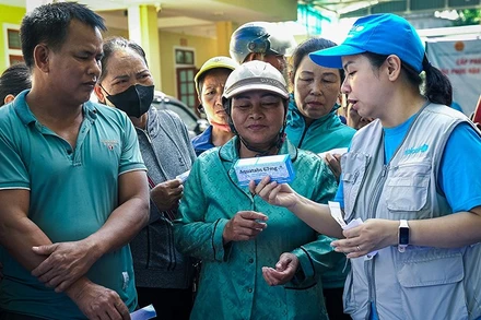 Cán bộ của UNICEF với người dân ở vùng bị ảnh hưởng bởi lũ lụt, sạt lở đất do hoàn lưu của bão số 3. (Ảnh UNICEF)