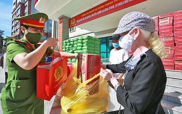 Các chiến sĩ công an quận Hà Đông trao quà tặng người dân có hoàn cảnh khó khăn.