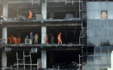 Lực lượng cứu hộ triển khai tại hiện trường vụ cháy ở New Delhi. (Ảnh REUTERS)