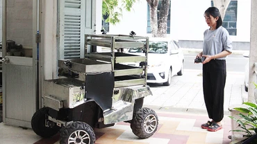 Phan Thị Mai đang điều khiển xe robot chạy thử.