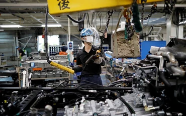 Vực dậy nền kinh tế là nhiệm vụ hàng đầu của Chính phủ Nhật Bản. Ảnh Reuters