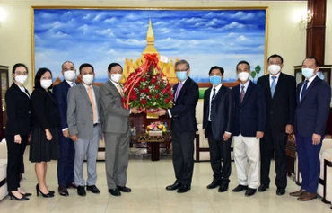 Đại sứ Nguyễn Bá Hùng (trái) chúc mừng và đánh giá cao những thành tựu phát triển kinh tế-xã hội mà Lào đạt được trong 46 năm qua. (Ảnh: Đại sứ quán Việt Nam tại Lào)