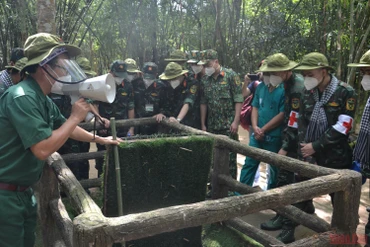 Du khách tham quan một hầm chông với nắp tự động của người dân Củ Chi. 