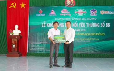 Lãnh đạo Công ty Nhựa Tiền phong trao bảng tượng trưng. (Ảnh: BÁ DŨNG) 