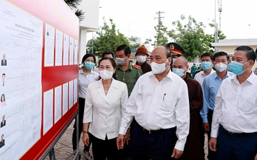 Chủ tịch nước Nguyễn Xuân Phúc xem danh sách các ứng cử viên đại biểu Quốc hội niêm yết tại xã Trung Chánh, huyện Hóc Môn. Ảnh: Thống Nhất (TTXVN)