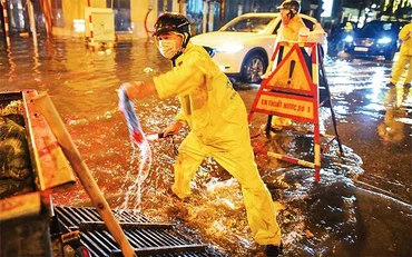 Công nhân Xí nghiệp thoát nước số 1, Công ty TNHH một thành viên Thoát nước Hà Nội ứng trực tại một điểm úng ngập trên địa bàn quận Hoàn Kiếm. (Ảnh: THÀNH ĐẠT)
