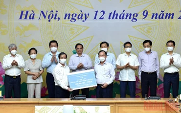 Thủ tướng Phạm Minh Chính và nhiều lãnh đạo chứng kiến các đơn vị trao tặng máy tính cho chương trình. (Ảnh: TRẦN HẢI)