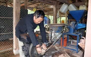 Ông Pờ Dần Sinh sửa máy xay xát thóc phục vụ người dân trong bản. 