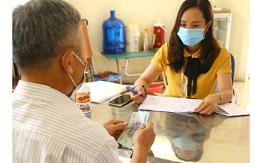 Chi trả hỗ trợ cho người bị ảnh hưởng bởi Covid-19 theo Nghị quyết 68 ở phường Thạch Bàn, quận Long Biên, Hà Nội (Ảnh: Hoàng Hiếu)