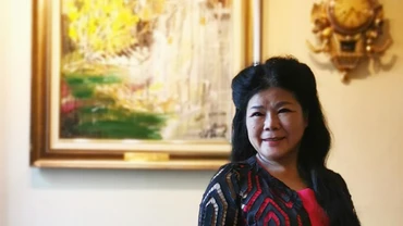 Họa sĩ Văn Dương Thành bên bức họa Văn Cao do chị vẽ. Ảnh: NGUYỄN LÂN NGỌC