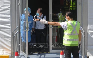 Nhân viên hướng dẫn hành khách trong chương trình Làn đi lại cho người đã tiêm vaccine (VTL), tại Singapore . (Ảnh: THX/TTXVN)